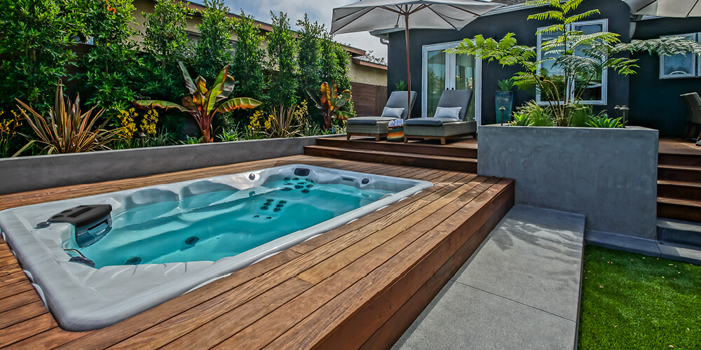 Sun umbrellas and deck chairs set around a Therapool swim spa.